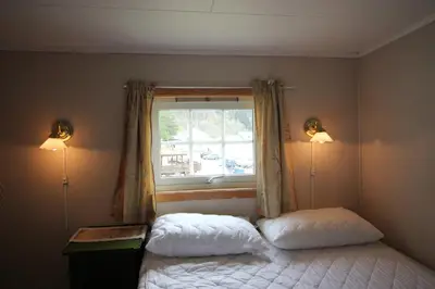 a bedroom with two beds and a window at Gjerdset Turistsenter in Isfjorden