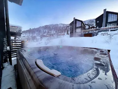 a hot tub covered in snow in a resort at Stranda Fjellgrend - with jacuzzi & 3 bedrooms in Stranda