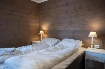 a bed in a room with two lamps on tables at Stranda Fjellgrend - with jacuzzi & 3 bedrooms in Stranda