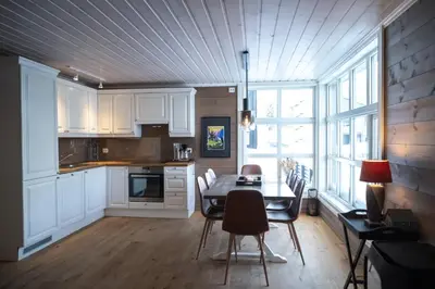 a kitchen with a table and chairs and a dining room at Stranda Fjellgrend - with jacuzzi & 3 bedrooms in Stranda