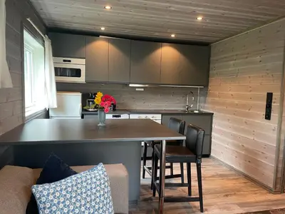 a kitchen with a table and chairs in a kitchen at Kvammen in Sæbø