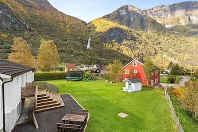 a yard with a red house and a playground at Fint hus i Flåm in Aurland
