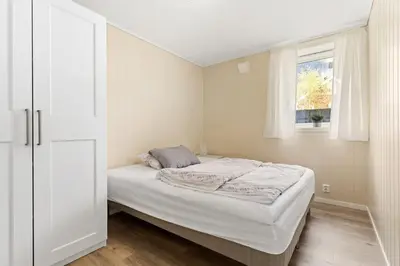 a white bedroom with a bed and a window at Fint hus i Flåm in Aurland