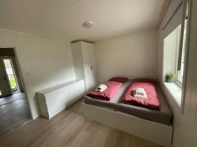 a small bedroom with a bed with red sheets at Fint hus i Flåm in Aurland