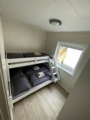 a small room with bunk beds and a window at Fint hus i Flåm in Aurland