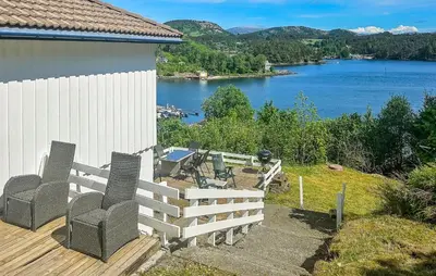 a deck with chairs and a view of a lake at Cozy Apartment In Sveio With Kitchen in Sveio