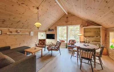 a living room with a couch and a table at 2 Bedroom Cozy Home In Finnås in Grutle