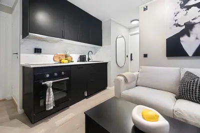a kitchen and living room with a couch and a table at King bed - Renovated 2024 - 2BR Behind Bryggen in Bergen