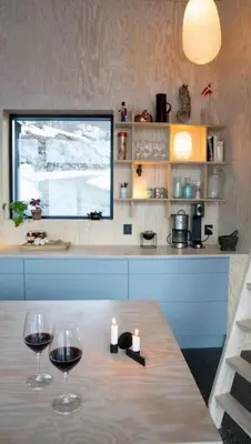 two glasses of wine sitting on a table in a kitchen at Cozy Nature Retreat, Danish Design w Jacuzzi option in Sogndal
