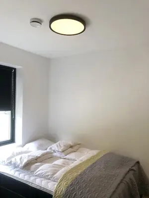 a bedroom with a bed with a light on the ceiling at Cozy Nature Retreat, Danish Design w Jacuzzi option in Sogndal