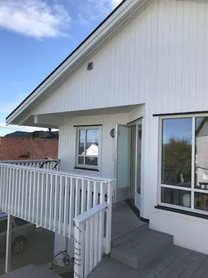 a white house with a porch and a door at Familiebolig med nydelig utsikt in Trondheim