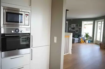 a kitchen with stainless steel appliances and a living room at Familiebolig med nydelig utsikt in Trondheim