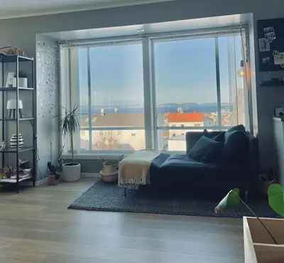 a living room with a couch and a large window at Familiebolig med nydelig utsikt in Trondheim