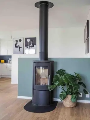 a black stove in a room with a potted plant at Familiebolig med nydelig utsikt in Trondheim