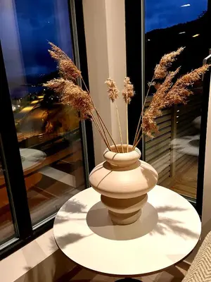 a vase with dried plants in it on a table at Sognefjorden View in Leikanger