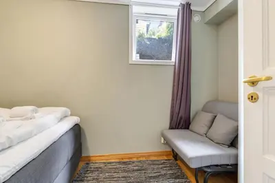 a bedroom with a bed and a chair and a window at Easy Living in Bergen