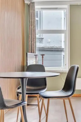 a dining room with a table and chairs and a window at Easy Living in Bergen