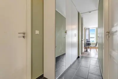 a hallway with green walls and a door and a table at Easy Living in Bergen