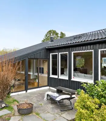 a black house with large windows and a bench at Tranquil Haven Villa in Ålesund