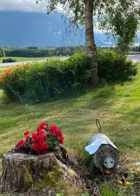 a statue of a bear in the grass with flowers at Heinåli apartment in Isfjorden