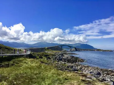 people walking on a bridge over a body of water at Heinåli apartment in Isfjorden