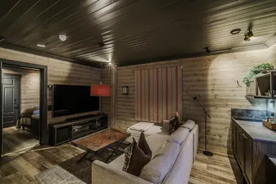 a living room with a couch and a television at Bokhandel'n Gjestehus in Vågåmo