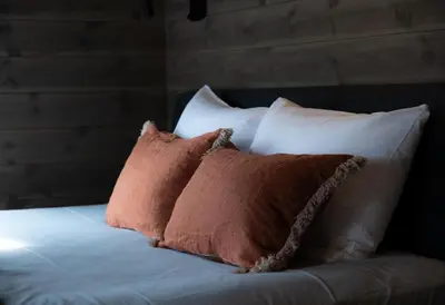 a bed with three pillows on top of it at Bokhandel'n Gjestehus in Vågåmo