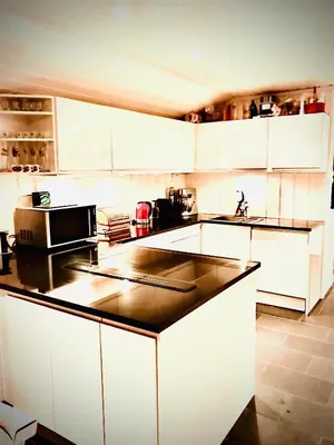 a kitchen with white cabinets and a black counter top at Hytta for 8 personer skiut/inn in Trysil