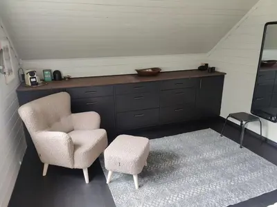 a living room with a chair and a stool at Fritt beliggende stor enebolig med høy standard in Rjukan