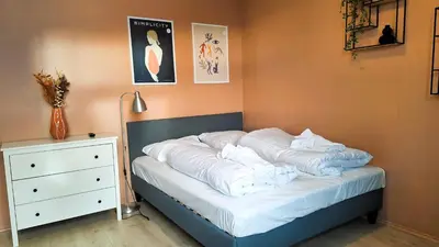 a bed with white pillows on it in a room at Sentrumsnær leilighet - K1 in Lillehammer