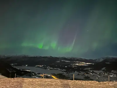 an image of the aurora in the sky over a city at Apartment with beautiful panoramic view in Skulestadmo