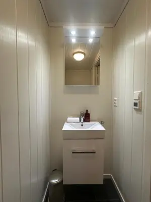 a bathroom with a white sink and a mirror at Apartment with beautiful panoramic view in Skulestadmo