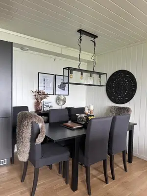 a dining room with a black table and chairs at Apartment with beautiful panoramic view in Skulestadmo