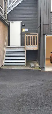 a wooden bench sitting in front of a building at Sentral leilighet på Geilo in Geilo