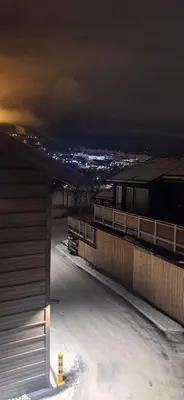 a night view of a building with snow on the ground at Sentral leilighet på Geilo in Geilo
