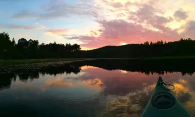a kayak on a river at sunset at Stabburet på Balsnes Gård in Hitra