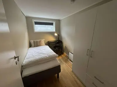 a small bedroom with a bed and a window at Apartment close to Aalesund center in Ålesund