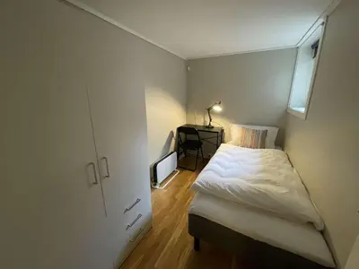 a small bedroom with a bed and a window at Apartment close to Aalesund center in Ålesund