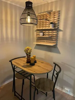 a wooden table with a chair and a pendant light at Apartment close to Aalesund center in Ålesund