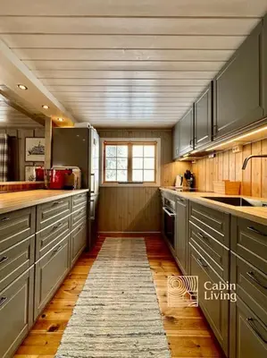 a large kitchen with gray cabinets and a window at Family-friendly cabin at Sjusjøen with ski trails, sauna and fireplace in Ringsaker