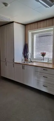 a kitchen with white cabinets and a window and a sink at Hus i flott natur in Skjåk