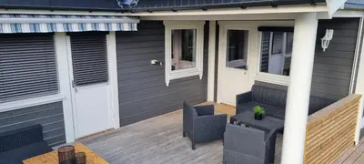 a house with a wooden deck with a chair at Hus i flott natur in Skjåk