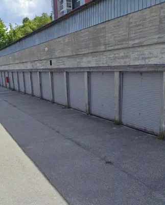 a row of four garage doors on a building at Leilighet med nydelig utsikt over Bergen in Bergen