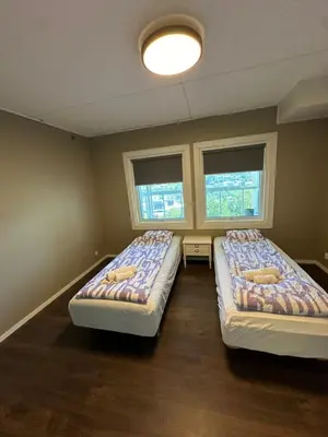 two beds in a room with two windows at Leilighet med nydelig utsikt over Bergen in Bergen