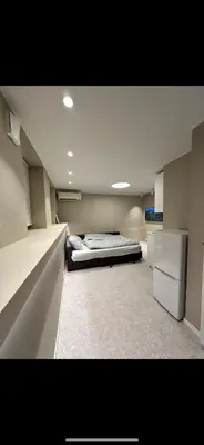 a large room with a bed and a refrigerator at Sparresgaten 2 in Bergen