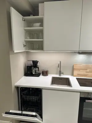 a kitchen with white cabinets and a sink at Sparresgaten 2 in Bergen