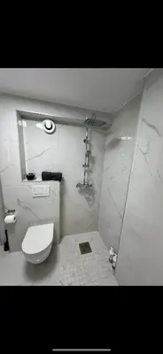 a white bathroom with a toilet and a shower at Sparresgaten 2 in Bergen