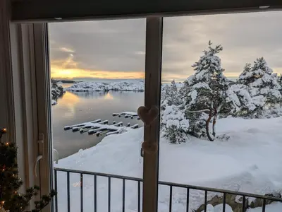 a window with a view of a lake in the snow at Svært nydelig fritidshytte in Forland