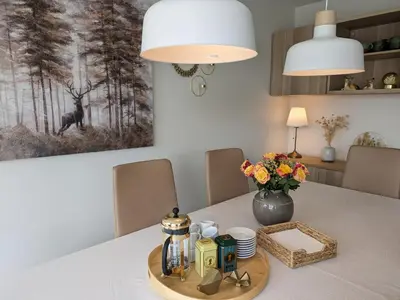 a table with a tray with a coffee maker and flowers at Svært nydelig fritidshytte in Forland