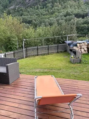 a bench on a deck with a view of a yard at Sentrumsnært hus in Rjukan